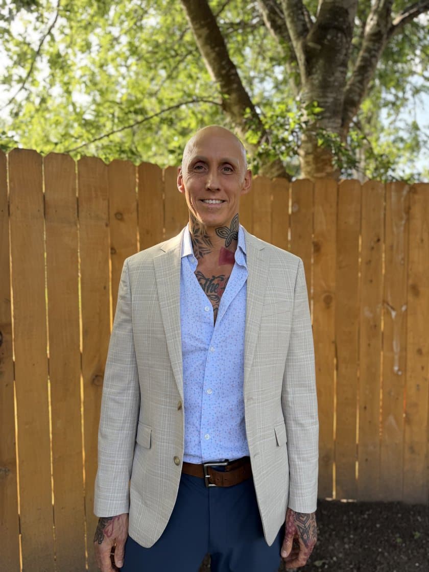 Sam Morris in a light suit jacket, standing outdoors